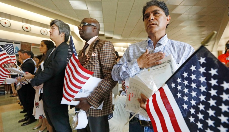 New citizens Eutropio Garcia Paz, of Mexico, right, Mamadou Sire Sall of Guinea, center, and Lucas Fei Lu of the People's Republic of China, were among 35 newly minted American citizens from 23 countries that sang the National Anthem at the conclusion of the naturalization ceremony at Northeast Jackson International Baccalaureate World Middle School in Jackson, Miss., Monday, Sept. 18, 2017.