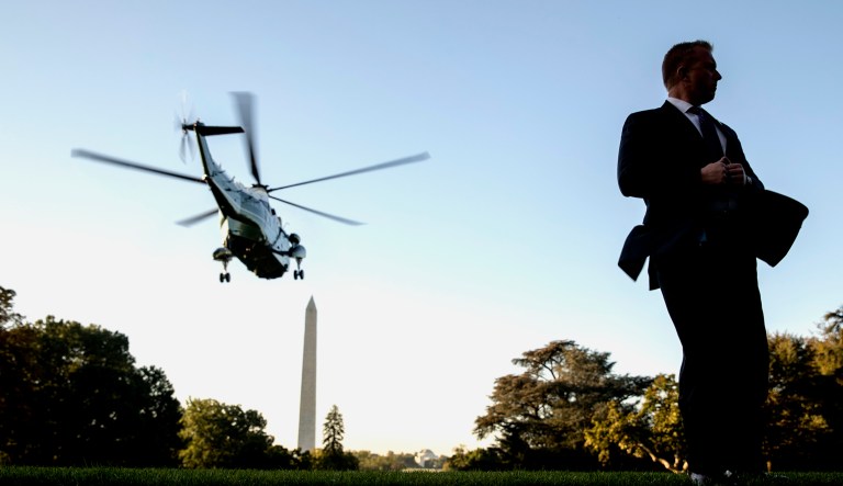 A Secret Service agent stands guard as Marine One, with President Trump aboard, departs from the South Lawn of the White House in Washington.