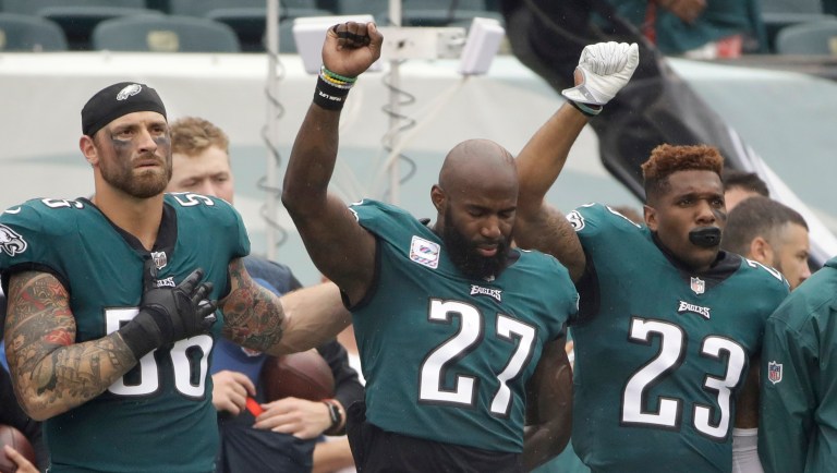 Philadelphia Eagles' Chris Long (56), Malcolm Jenkins (27) and Rodney McLeod (23) gesture during the National Anthem before an NFL football game against the Arizona Cardinals last year in Philadelphia. (AP Photo/Matt Rourke)