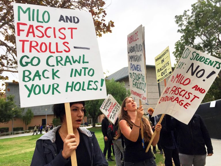 Demonstrators protest outside a speech by conservative provocateur Milo Yiannopoulos, sponsored by a Republican student group at California State University, Fullerton, Tuesday, Oct. 31, 2017. At least one fight broke out and several people were arrested. They were mostly peaceful, but one woman protesting the event attacked a Yiannopoulos supporter with punches before a third person subdued her with pepper spray.