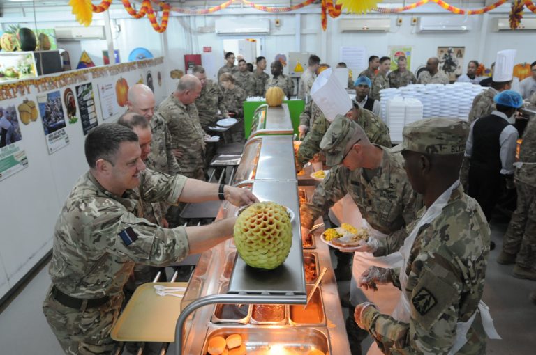 This photo released on Thursday, Nov. 23, 2017 by Combined Joint Task Force â Operation Inherent Resolve, the U.S-led effort against the Islamic State group, shows officers serving their soldiers Thanksgiving Day dinner in a dining facility at Camp Arifjan, Kuwait.