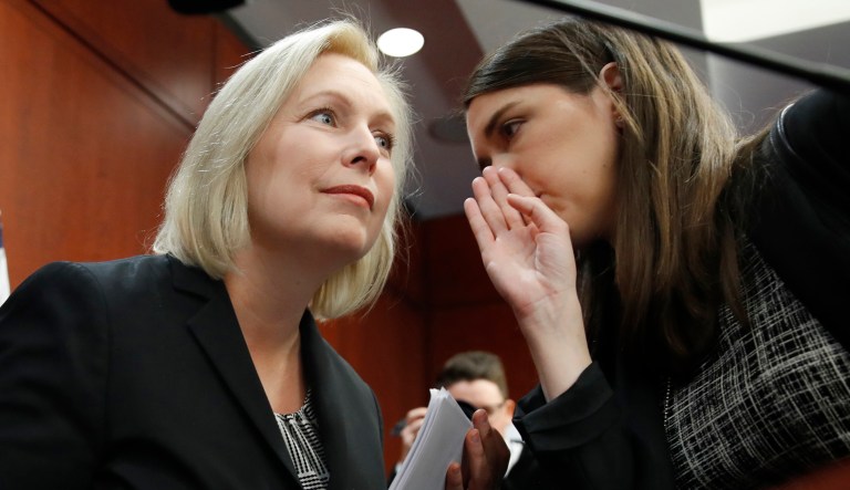 Sen. Kirsten Gillibrand, D-N.Y., listens to a staffer before answering questions at a news conference, Tuesday, Dec. 12, 2017, on Capitol Hill in Washington.