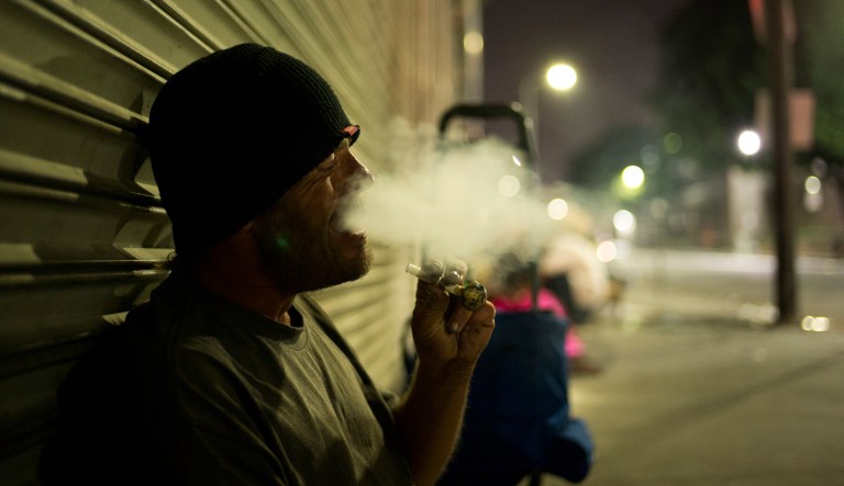 D. J. Meek, a 40-year-old homeless drug addict, smokes crystal meth Friday, Sept. 8, 2017, in the Skid Row area of downtown Los Angeles.