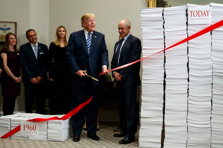President Trump cuts a ribbon during an event on federal regulations in the Roosevelt Room of the White House, Thursday, Dec. 14, 2017, in Washington.