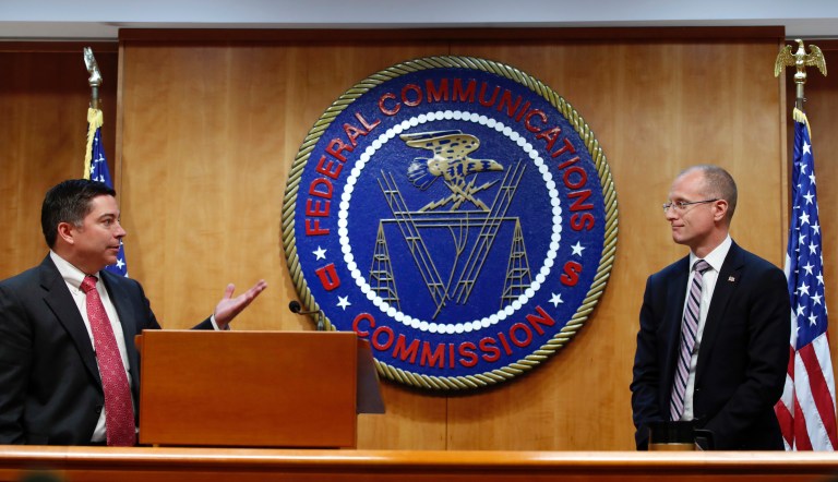 Federal Communications Commission (FCC) Commissioners Michael O'Rielly, left, and Brendan Carr, turn to answer a question from the media after an FCC meeting to vote on net neutrality, Thursday, Dec. 14, 2017, in Washington.