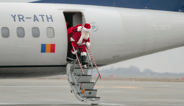 A person wearing a Santa Claus outfit gets out of an airplane during a Christmas event on the Henri Coanda airport, outside Bucharest, Romania, Tuesday, Dec. 19, 2017.