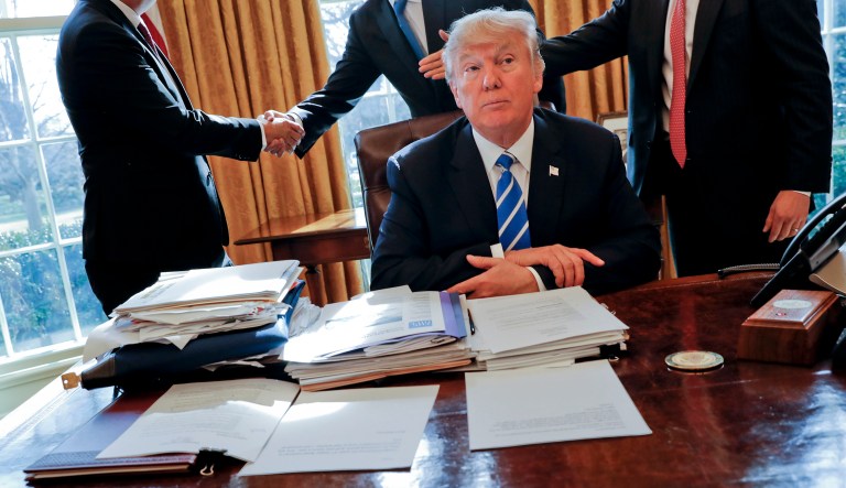 President Trump sits at his desk. 