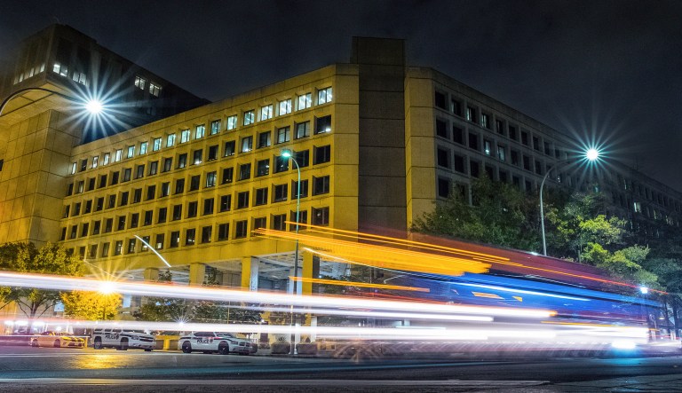 Traffic along Pennsylvania Avenue in Washington streaks past the Federal Bureau of Investigation headquarters building at night in Washington, D.C.