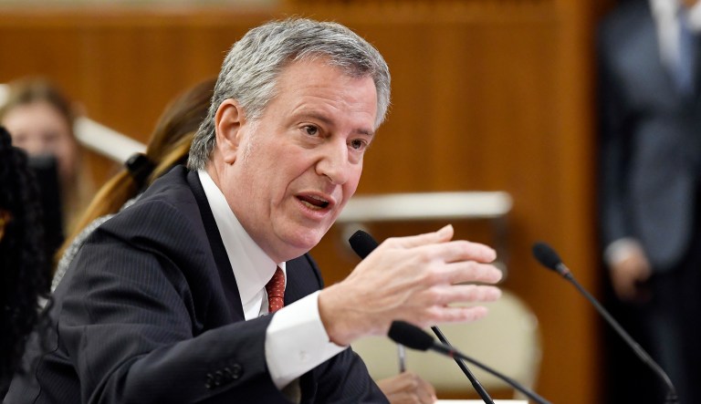 New York City Mayor Bill de Blasio talks to government officials.