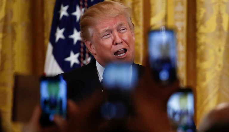 People in the audience hold up their smart phones as President Donald Trump speaks during the National African American History Month reception in the East Room of the White House in Washington, Tuesday, Feb. 13, 2018.
