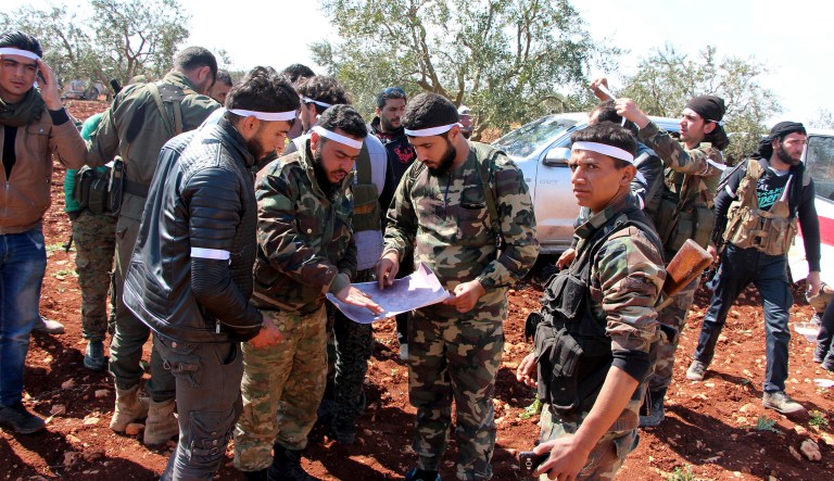 Turkey-backed Free Syrian Army fighters advance in Der Mismis village at the south east of Afrin, Syria, Tuesday, March 13. Turkish troops and allied Syrian opposition fighters have begun a siege of the Syrian Kurdish-held town of Afrin, the Turkish military said Tuesday.