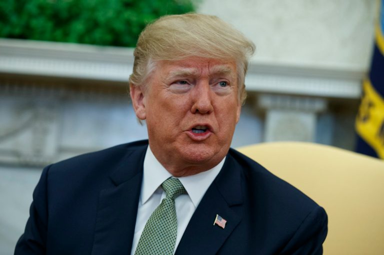 President Trump talks with reporters in the Oval Office of the White House.