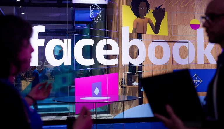 In this Tuesday, April 18, 2017, file photo, conference workers speak in front of a demo booth at Facebook's annual F8 developer conference, in San Jose, Calif.