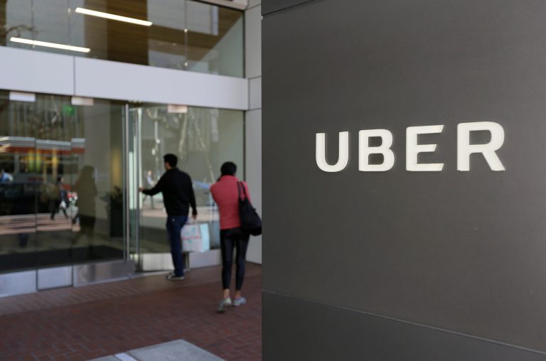 FILE - In this March 1, 2017 file photo, people enter the headquarters of Uber in San Francisco. Uber suspended all of its self-driving testing Monday, March 19, 2018, after what is believed to be the first fatal pedestrian crash involving the vehicles. The testing has been going on for months in the Phoenix area, Pittsburgh, San Francisco and Toronto as automakers and technology companies compete to be the first with the technology. Uber's testing was halted after police in a Phoenix suburb said one of its self-driving vehicles struck and killed a pedestrian overnight Sunday.