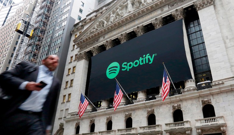 A Spotify banner adorns the facade of the New York Stock Exchange, Tuesday, April 3, 2018. Spotify, the No. 1 music streaming service which has drawn comparisons to Netflix, is about to find out how it plays on the stock market in an unusual IPO.
