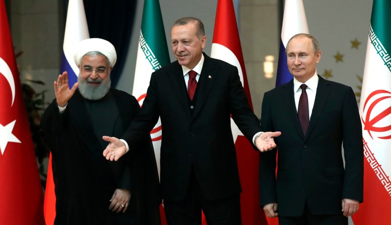 Iranian President Hassan Rouhani (left), Russian President Vladimir Putin (right), and Turkish President Recep Tayyip Erdogan wave after a group photo.