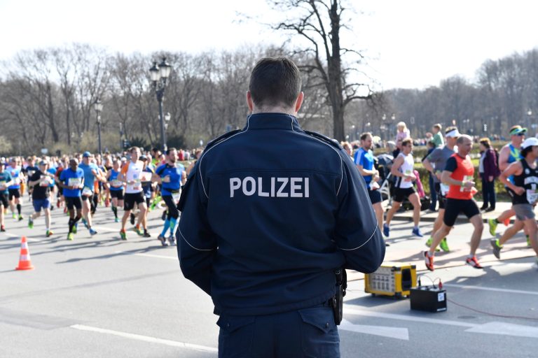 Police guard during the half marathon run in Berlin, Sunday, April 8, 2018. The German daily Die Welt is reporting that police have foiled a knife attack on a half-marathon in Berlin. The paper says special police forces detained four men in connection with Sunday's sports event. They said the main suspect was planning to kill participants and spectators with knives.