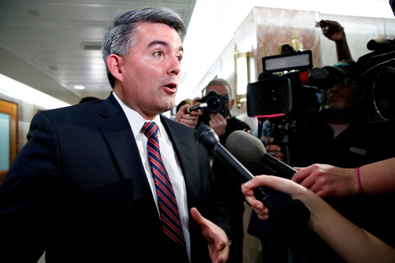 Sen. Cory Gardner, R-Colo., left, speaks to the media on Capitol Hill in Washington.