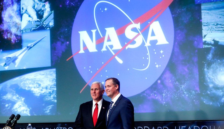 Vice President Mike Pence, left, shakes hands with the new NASA administrator Jim Bridenstine, right, on stage at NASA Headquarters in Washington.