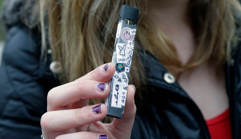 In this Wednesday, April 11, 2018 photo, an unidentified 15-year-old high school student displays a vaping device near the school's campus in Cambridge, Mass. Schools and health officials across the U.S. are struggling to curb what they say is an epidemic of underage vaping. Officials say teens and children are getting easy access to e-cigarettes and other vaping devices, which heat liquid into an inhalable vapor that often contains nicotine.