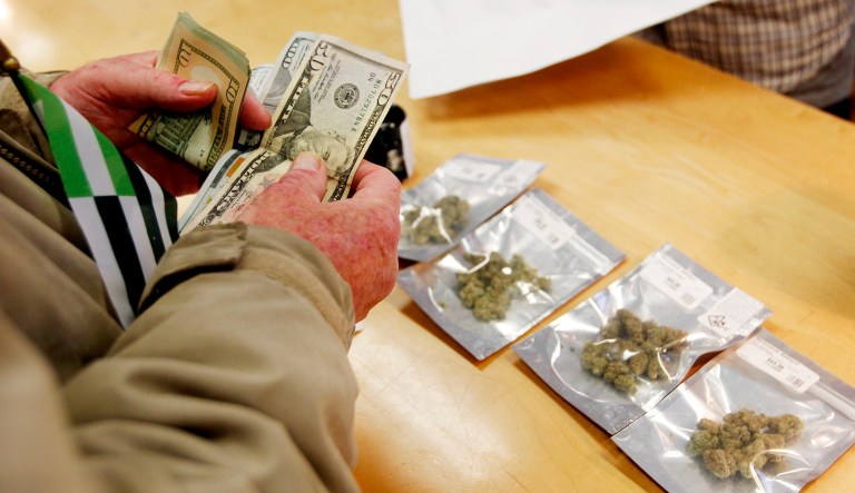 A customer purchases marijuana at the Harborside marijuana dispensary in Oakland, Calif.,