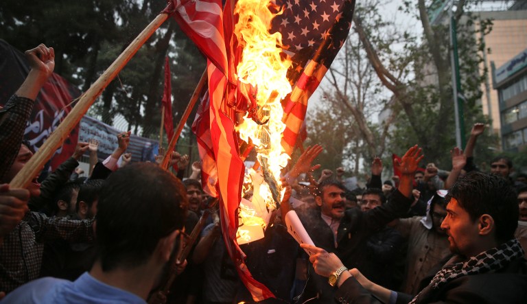 Hardline Iranian demonstrators burn representations of the U.S. flag during a gathering in front of the former U.S. Embassy in Tehran, Iran, Wednesday, May 9, 2018, reacting to President Donald Trump's decision to pull out of the nuclear deal and renew sanctions on Iran. (AP Photo/Vahid Salemi)