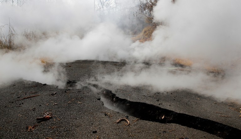 Toxic gases rise from cracks in the Leilani Estates subdivision near Pahoa, Hawaii, Friday, May 11, 2018. Kilauea has destroyed more than 35 structures since it began releasing lava from vents about 25 miles (40 kilometers) east of the summit crater. 