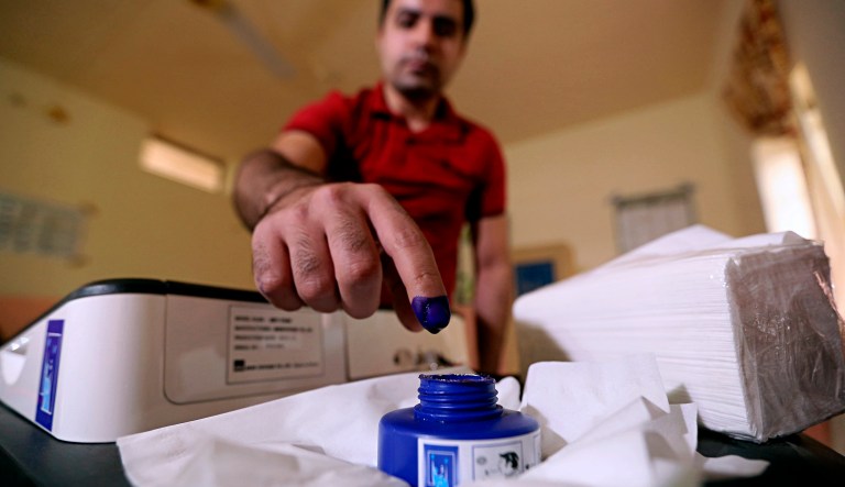 An Iraq man inks his finger after casting his ballot in the country's parliamentary elections in Ramadi, Iraq, Saturday, May 12, 2018. Polls opened across Iraq on Saturday in the first national election since the declaration of victory over the Islamic State group.