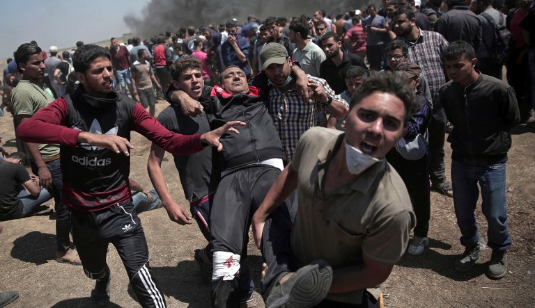 Palestinian protesters carry an injured man who was shot by Israeli troops during a deadly protest at the Gaza Strip's border with Israel, east of Khan Younis, Gaza Strip, Monday, May 14, 2018. Thousands of Palestinians are protesting near Gaza's border with Israel, as Israel celebrates the inauguration of a new U.S. Embassy in contested Jerusalem. 