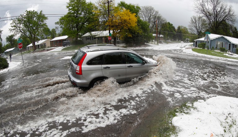 A motorist drives through a flooded intersection after a spring storm packing heavy rains and hail hit Monday, May 14, 2018, in southeast Denver. The high-powered storm swept over the area and dumped large amounts of marble-sized hail and heavy rain, snarling traffic in densely-populated parts of the metropolitan area.