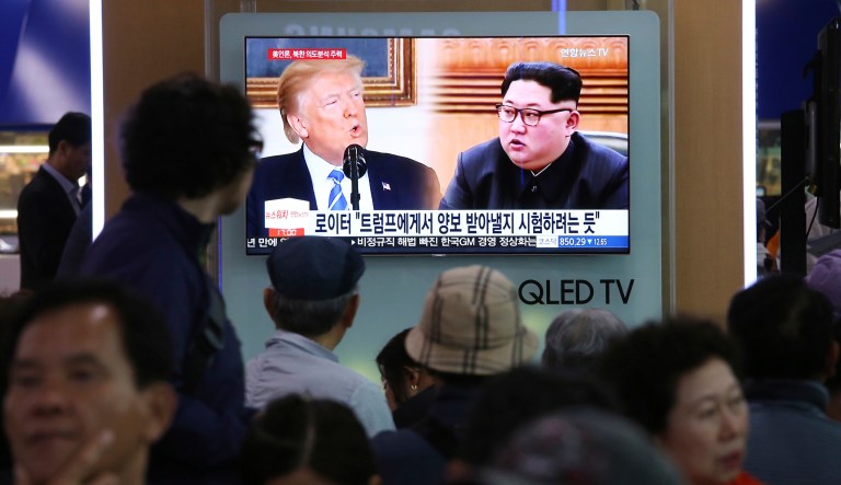 People watch a TV screen showing file footage of U.S. President Donald Trump, left, and North Korean leader Kim Jong Un during a news program at the Seoul Railway Station in Seoul, South Korea, Wednesday, May 16, 2018. North Korea on Wednesday threatened to scrap a historic summit next month between its leader, Kim Jong Un, and U.S. President Donald Trump, saying it has no interest in a "one-sided" affair meant to pressure Pyongyang to abandon its nuclear weapons. The signs read: " Trying to test Trump." 