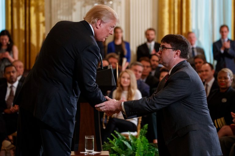 President Donald Trump shakes hands with acting Department of Veterans Affairs Secretary Robert Wilkie after announcing he will nominate him to lead the department during an event on prison reform in the East Room of the White House, Friday, May 18, 2018, in Washington.