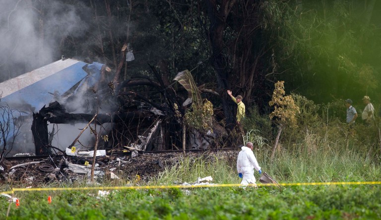 Forensic investigators and Ministry of Interior officers sift through remains of a Boeing 737 that plummeted into a yuca field with more than 100 passengers on board, in Havana, Cuba, on Friday.