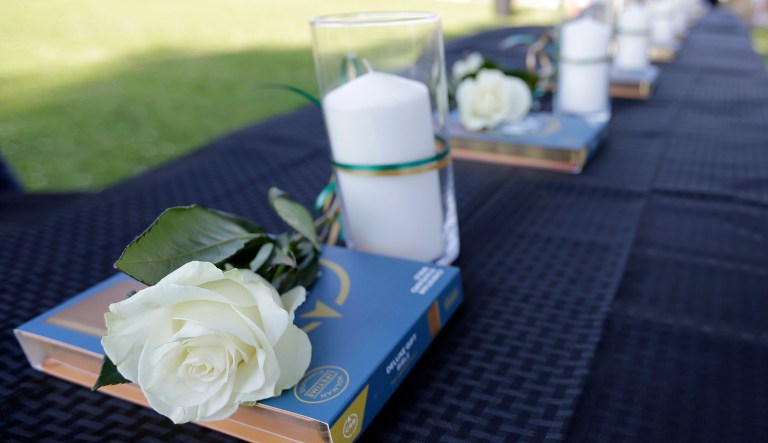 Ten candles, roses and bibles are displayed on a table during a prayer vigil following a shooting at Santa Fe High School in Santa Fe, Texas, on Friday, May 18, 2018. Seventeen-year-old Dimitrios Pagourtzis is charged with capital murder in the shooting rampage. A judge denied him bond at a court hearing Friday evening.