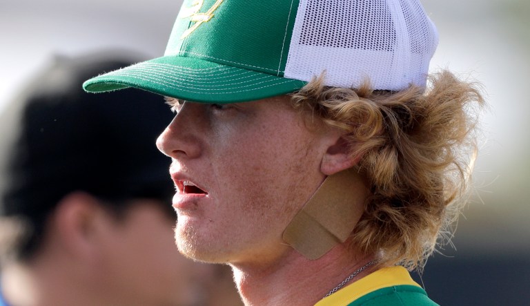Santa Fe High School baseball player Rome Shubert wears a bandage on his neck before a baseball game against Kingwood Park High School in Deer Park, Texas, Saturday, May 19, 2018. A gunman opened fire inside Santa Fe High School Friday, May 18, 2018, killing at least 10 people. Shubert was hit in the neck during the shooting.