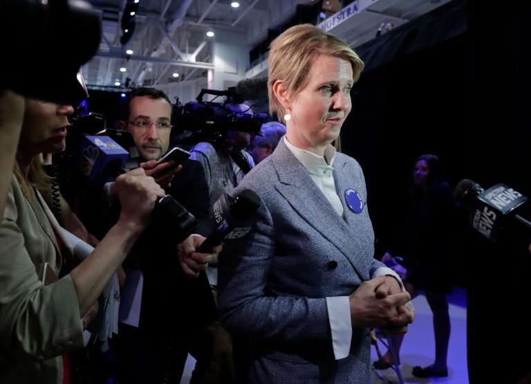 New York gubernatorial nominee Cynthia Nixon, right, answers questions for the media as she leaves the New York state Democratic convention, Wednesday, May 23, 2018, in Hempstead, N.Y.