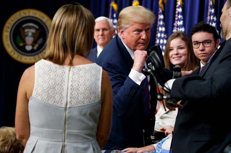 President Donald Trump greets patients on stage as he arrives for a bill signing ceremony for the "Right to Try" act in the South Court Auditorium on the White House campus, Wednesday, May 30, 2018, in Washington.
