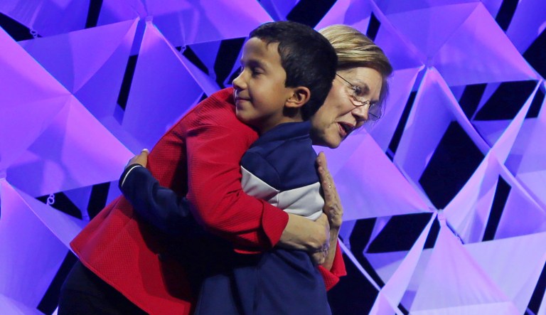 Sen. Elizabeth Warren hugs her grandson, Atticus Mann Tyagi, who introduced her to speak at the 2018 Massachusetts Democratic Party Convention, June 1, 2018, in Worcester, Mass.