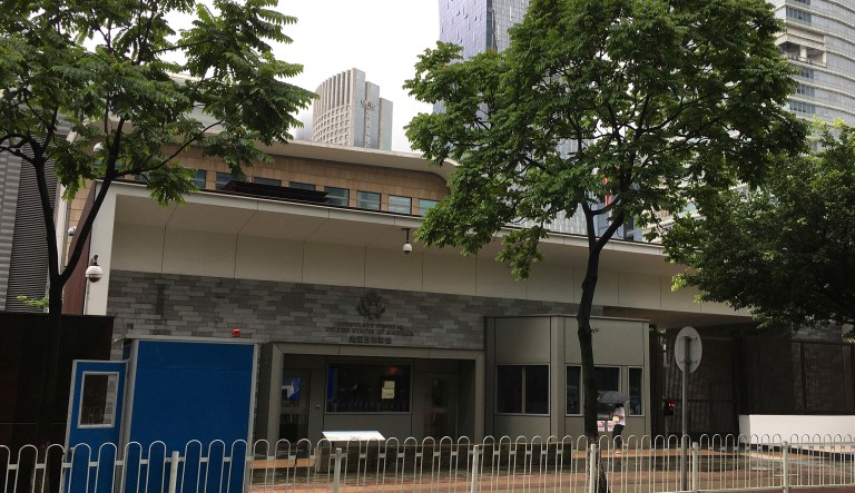A woman walks by the U.S. consulate building in Guangzhou in south China's Guangdong province on June 7. The U.S. has evacuated several more of its workers out of China after medical testing revealed they might have been affected by unexplained health incidents that have hurt U.S. personnel in Cuba and China.