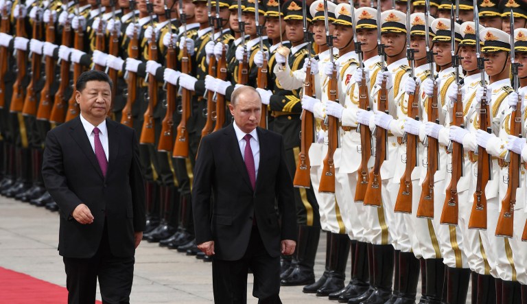 Russia's President Vladimir Putin, center, reviews a military honor guard with Chinese President Xi Jinping during a welcoming ceremony outside the Great Hall of the People in Beijing Friday, June 8, 2018.