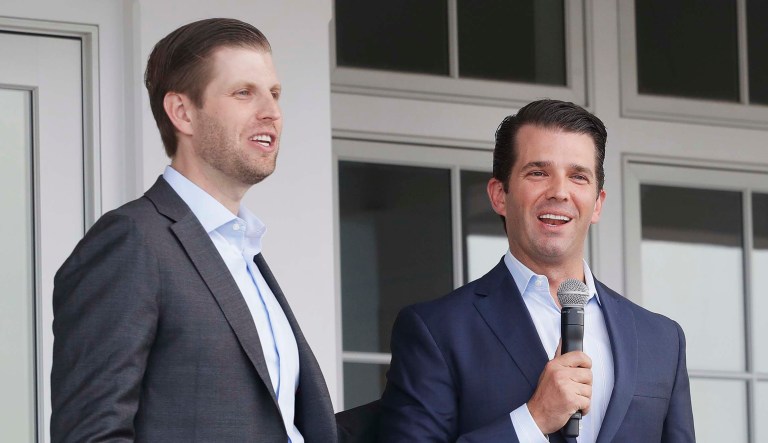 Eric Trump, left, and his brother Donald Trump Jr. talk at an event.