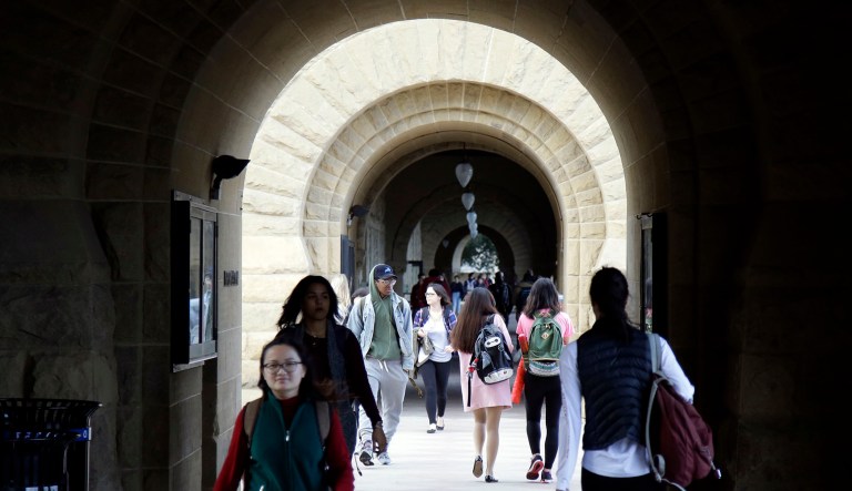 Students walk on campus at Stanford University in Stanford, Calif.