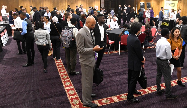 People wait to talk to potential future employers at a job fair in Chicago.