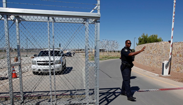 An agent with the Department of Homeland Security controls access to a holding facility for immigrant children in Tornillo, Texas, near the Mexican border, on Thursday.