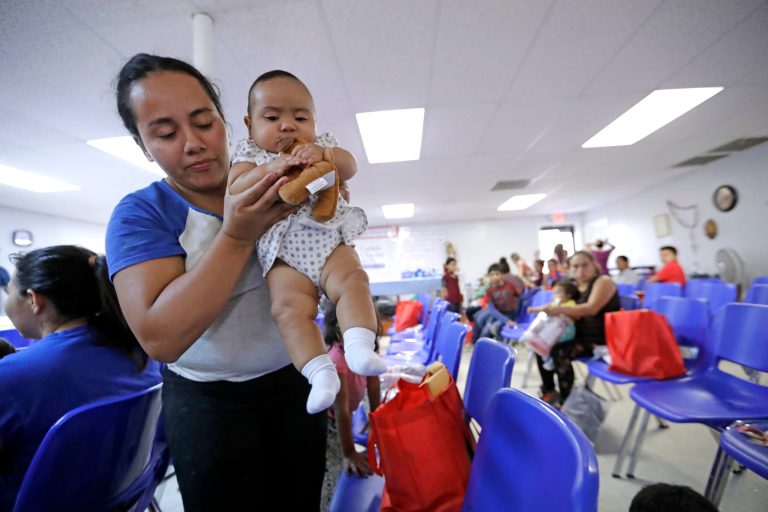 An immigrant woman from Honduras carries her baby inside the Catholic Charities of the Rio Grande Valley on Saturday, June 23, 2018, in McAllen, Texas. Families, who have been processed and released by U.S. Customs and Border Protection, wait inside the facility before continuing their journey to cities across the United States.