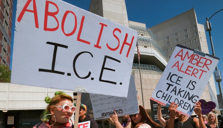 Protesters carry signs during a rally in front of the Immigration and Customs Enforcement facility in downtown Los Angeles on July 2, 2018.