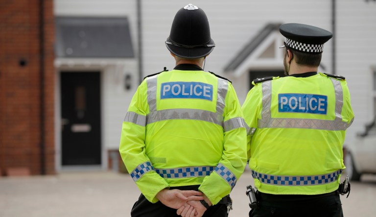 British police officers stand facing a residential property in Amesbury, England, Wednesday, July 4, 2018. British police have declared a "major incident" after two people were exposed to an unknown substance in the town, and are cordoning off places the people are known to have visited before falling ill.