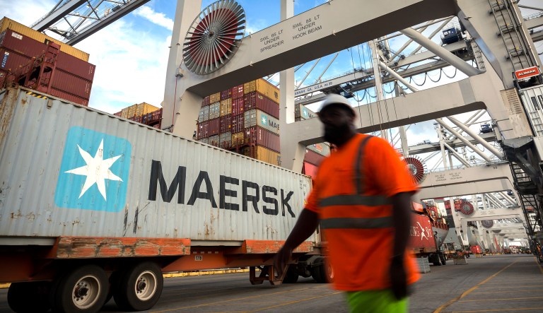 A longshoreman prepares to direct the next shipping container to be picked up by a ship to shore crane at the Port of Savannah in Savannah, Ga.