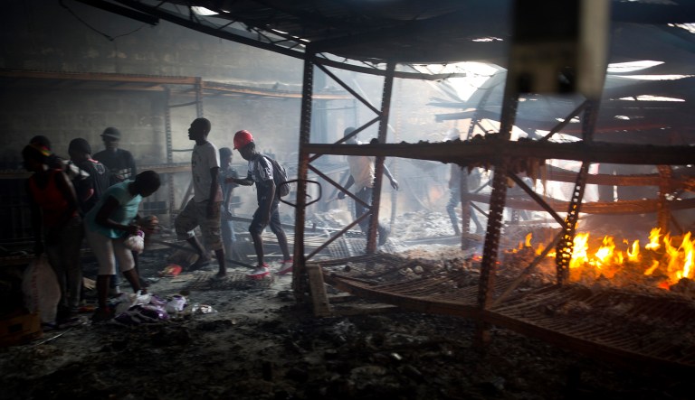 People loot a Delimart store that was burned during two days of protests against a planned hike in fuel prices in Port-au-Prince, Haiti, Sunday, July 8, 2018. Government officials had agreed to reduce subsidies for fuel as part of an assistance package with the International Monetary Fund, but the government suspended the fuel hike after widespread violence broke out. 