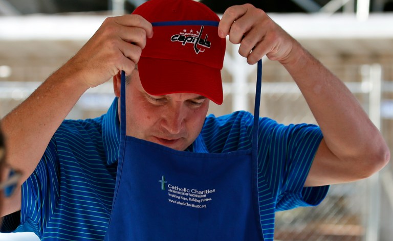 Supreme Court nominee Brett Kavanaugh puts on his apron to serve meals to the homeless as he volunteers with Catholic Charities, Wednesday, July 11, 2018 in Washington.